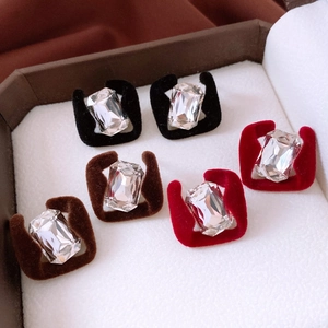 Detailed macro view of square fuzzy velvet earrings with sparkling center crystals