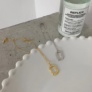 Macro shot of irregular branch-textured gold and silver pendants on a ceramic plate