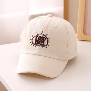 Dettaglio del ricamo 'GOOD VIBES' su un cappellino da baseball in cotone crema