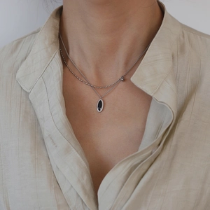 Détail d'un collier double rang en acier titane avec pendentif ovale noir vintage
