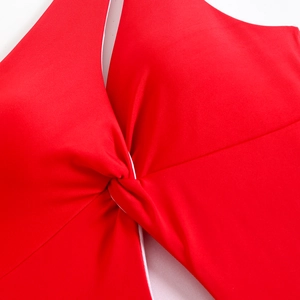 Detailed close-up of red one-shoulder swimsuit with cross-knot design and ribbed texture