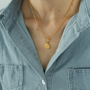Golden OT toggle necklace with double chain design and Beloved pendant on denim shirt