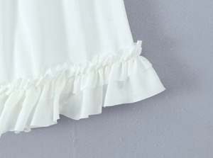 Detailopname van de witte ruiszoom op een rok met hoge taille en zachte stofstructuur