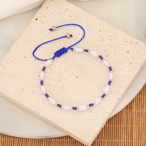 Detail of beaded bracelet with irregular pearls, blue beads and adjustable woven cord