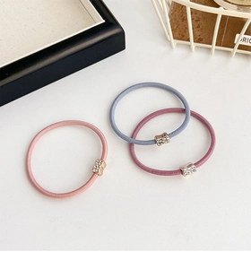Detailed view of pink, blue, and purple elastic hair ties with sparkling rhinestone metal accents