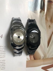 Macro detail of Y2K oval quartz watches in silver and black with metal wristbands
