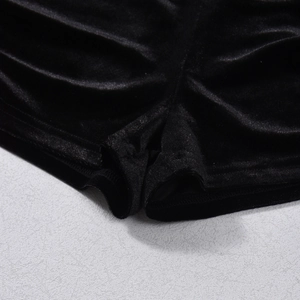 Detailed close-up of high-elastic black velvet fabric and stitching on slim fit shorts
