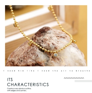 Macro shot of 18K gold-plated beaded necklace with sparkling round zircon accents on stone