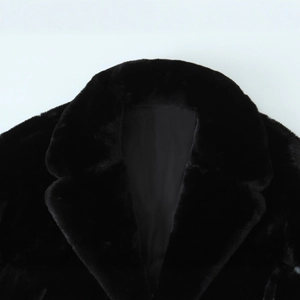 Gros plan d'une veste noire en fausse fourrure montrant le col et les fibres douces