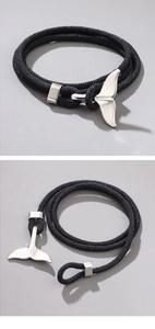 Close-up of beach ocean whale tail bracelet with black woven multi-wrap cord