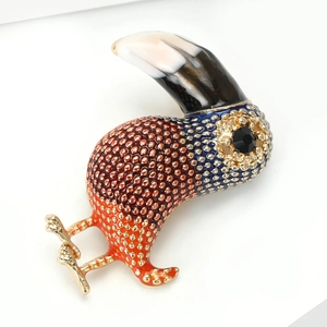 Macro shot of colorful enamel cormorant bird brooch with detailed golden grain textures