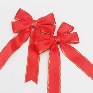 Detail showing red velvet Christmas bows with elegant gold metallic edges on white background