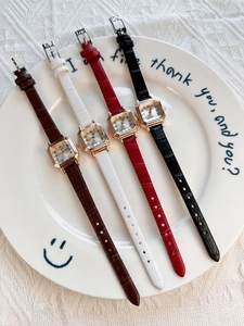 Detail view of four elegant square gold women's watches with colorful leather straps