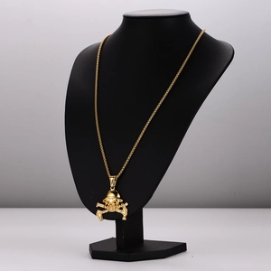Vintage gold skull and crossbones stainless steel pendant necklace on black display