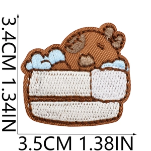 Dettaglio di una toppa ricamata a forma di orso bruno con misure 3,5 cm x 3,4 cm