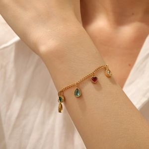 Detailed close-up of gold-plated bracelet with colorful heart and teardrop crystal charms