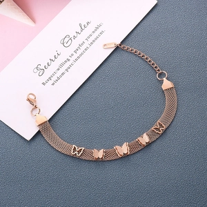 Bracelet papillon en maille or rose avec cinq breloques sur fond bleu texturé