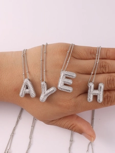 Detail view of 3D bubble initial necklaces with zircon inlay on a delicate silver chain