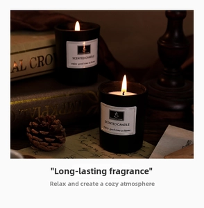 Close-up of black frosted glass scented candle with minimalist label in warm cozy setting