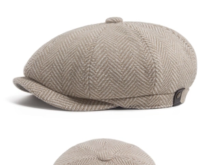 Detailed view of beige herringbone baker boy hat showing premium fabric texture and leather tab