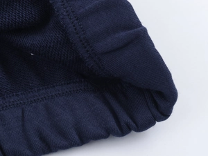 Gros plan détaillé des poignets du sweat-shirt bleu foncé montrant la texture du tissu