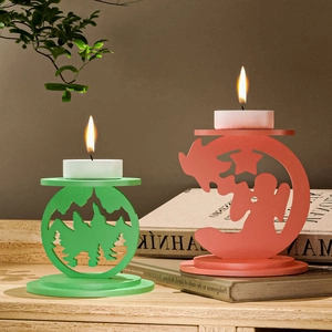 Detail of pine tree and angel silhouette metal candle holders with warm tea light glow