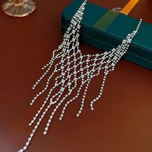 Detailed view of silver tassel necklace with rhinestones on a jewelry box
