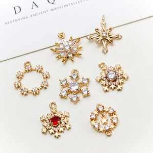 Detailansicht von vergoldeten Schneeflocken und Sternanhängern mit Zirkonia für DIY-Schmuck