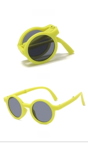 Detailed view of yellow folding kids sunglasses in both compact and unfolded positions