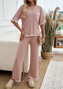 Détail de l'ensemble en tricot rose avec bordures blanches sur la poche et le bas fendu