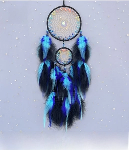 Detail view of handmade bohemian dream catcher with blue feathers and moon pendant