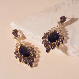 Detail of vintage drop earrings with purple teardrop crystals and gold zircon settings
