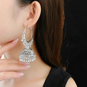 Close-up of vintage silver Jhumka earrings with intricate metal bead tassels on model