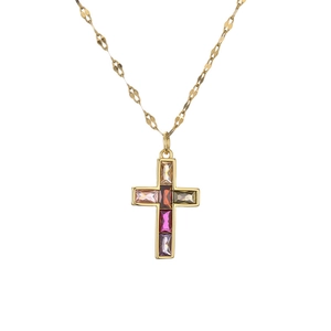 Dettaglio del ciondolo a croce con gemme rettangolari colorate su collana dorata