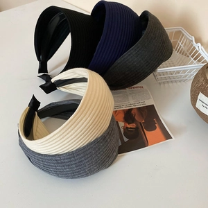 Detail der gerippten Strickstruktur auf breiten Stirnbändern in Schwarz und Creme