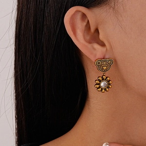 Vintage gold bear and sunflower earrings with zircon stones on female model ear