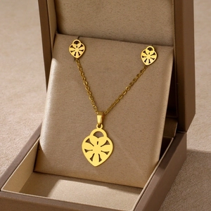 Detailed shot of golden heart-shaped floral jewelry set inside an elegant gift box