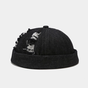 Close-up of distressed denim fabric and ripped details on a black miki hat