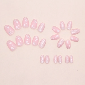 Detail of pink press on nails with white floral patterns and silver glitter finish