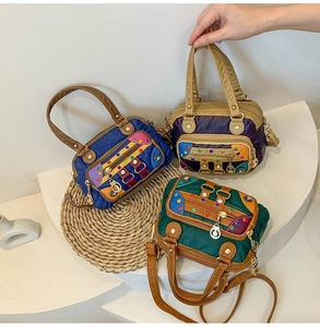 Detailed view of color-block washed leather handbags with rivets and zipper hardware