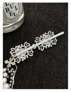 Detail showing silver metal hair clip with long pearl tassels and sparkling rhinestone fringe