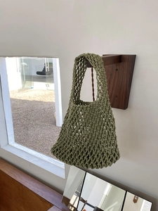 Detail of olive green hand-woven mesh tote bag with minimalist cotton rope design