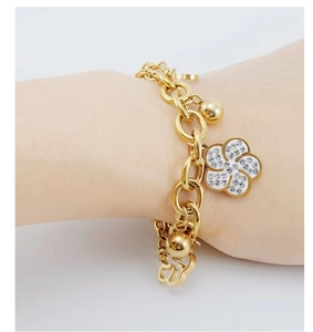 Close-up of golden rose bracelet featuring sparkling rhinestone flower and CD charms