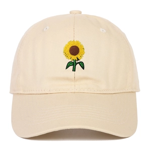 Close-up of sunflower embroidery on beige cotton baseball cap with ventilation eyelets