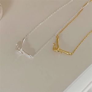Detailed macro view of S925 sterling silver and gold minimalist curved bar pendants