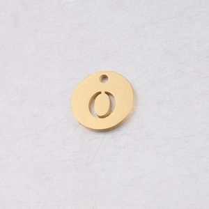 Vue macro d'un pendentif rond de 12 mm en acier doré avec lettre O découpée au miroir