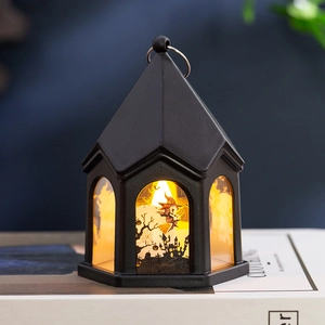 Détail d'une lanterne d'Halloween noire avec silhouette de sorcière et château et lumière LED