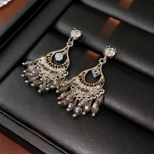 Détails des boucles d'oreilles argentées avec strass brillants et perles gris fumé