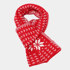 Detailed close-up of red knit scarf featuring white snowflake jacquard pattern for winter