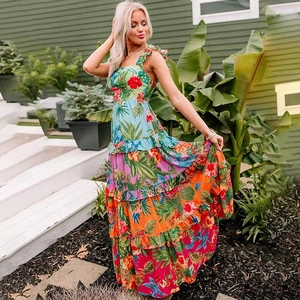 Detail of tropical floral print beach dress with tiered ruffle hem and palm leaf patterns